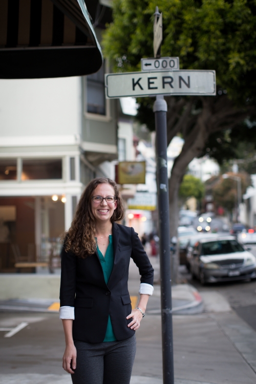 woman stands on street near sign